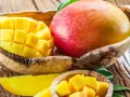 Dojrzałe mango w drewnianej misie, pokrojone w kostkę i plastry. To tropikalne owoce, które zachwycają smakiem i bogactwem witamin. Mango wartości odżywcze są imponujące.