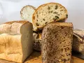 Różne rodzaje pieczywa, w tym bochenek z ziarnami, który może być odpowiedzią na pytanie: czy chleb razowy jest zdrowy?