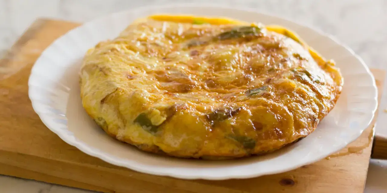 Złocista tortilla ziemniaczana z papryką na talerzu. Idealna jako pomysł na to, co zamiast chleba na śniadanie.