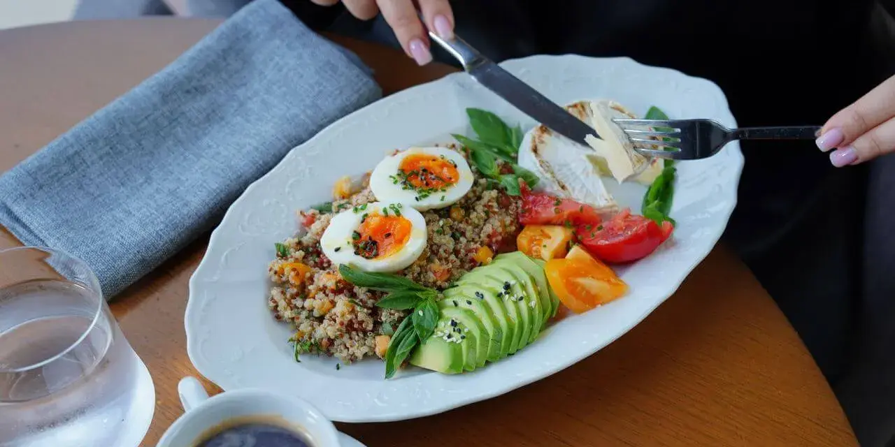 Zdrowy posiłek z jajkami, awokado i komosą ryżową, idealny na dietę 2000 kcal.
