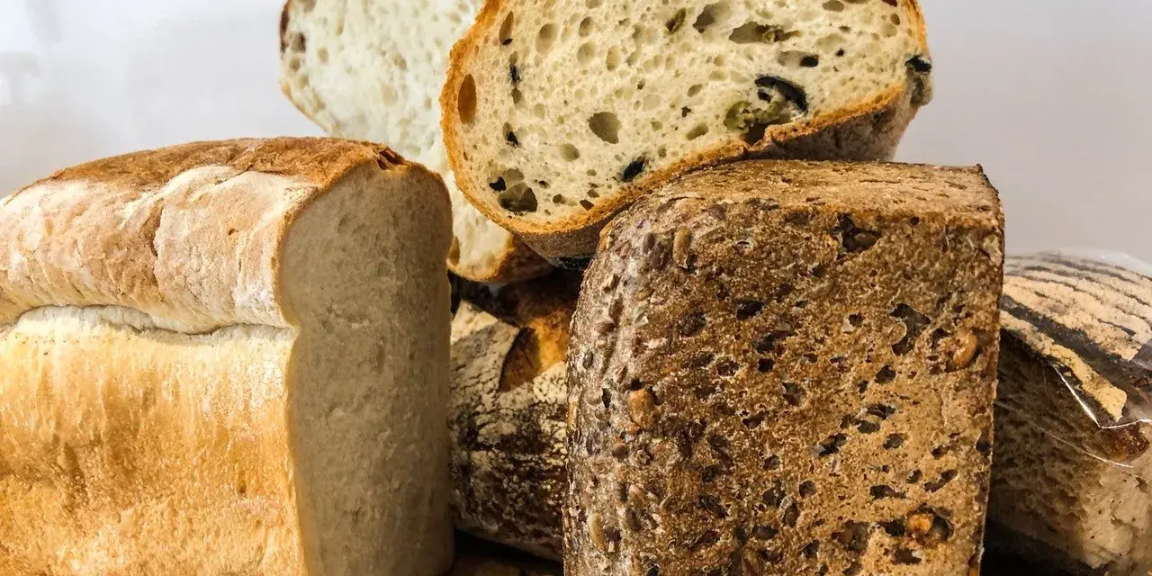 Różne rodzaje pieczywa, w tym bochenek z ziarnami, który może być odpowiedzią na pytanie: czy chleb razowy jest zdrowy?