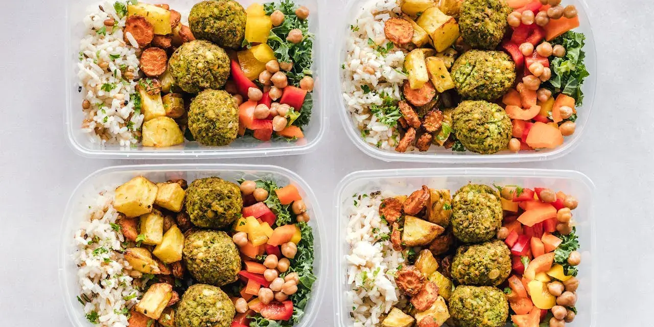 Cztery pojemniki z posiłkami: ryż, pieczone ziemniaki, marchewka, falafel, ciecierzyca i warzywa. Idealne na dieta 3000 kcal jadłospis tygodniowy.