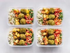 Cztery pojemniki z posiłkami: ryż, pieczone ziemniaki, marchewka, falafel, ciecierzyca i warzywa. Idealne na dieta 3000 kcal jadłospis tygodniowy.