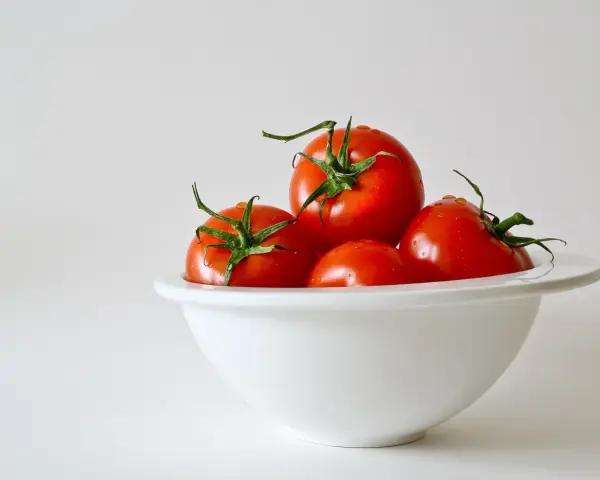 Kilka soczystych pomidorów w białej misce. Zastanawiasz się, ile węglowodanów ma pomidor?