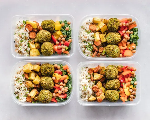 Cztery pojemniki z posiłkami: ryż, pieczone ziemniaki, marchewka, falafel, ciecierzyca i warzywa. Idealne na dieta 3000 kcal jadłospis tygodniowy.