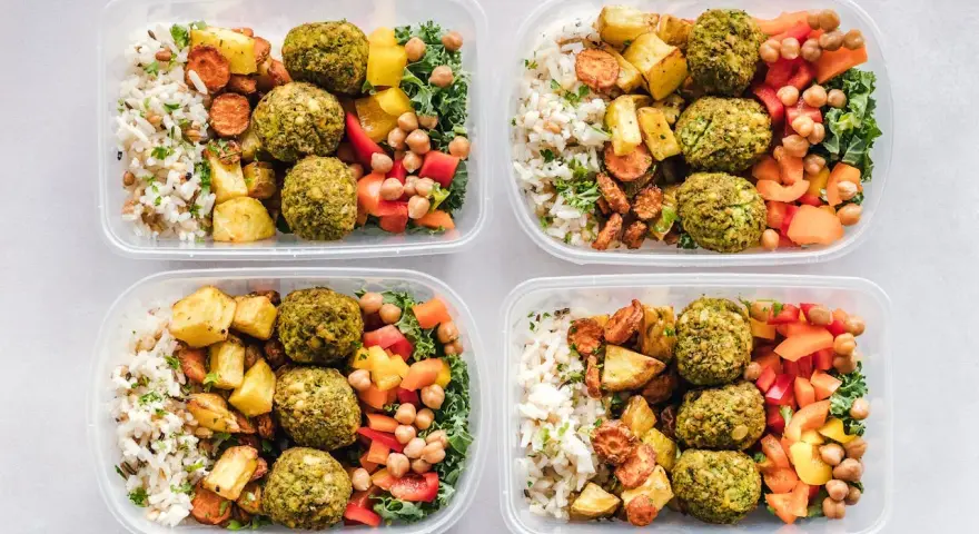 Cztery pojemniki z posiłkami: ryż, pieczone ziemniaki, marchewka, falafel, ciecierzyca i warzywa. Idealne na dieta 3000 kcal jadłospis tygodniowy.