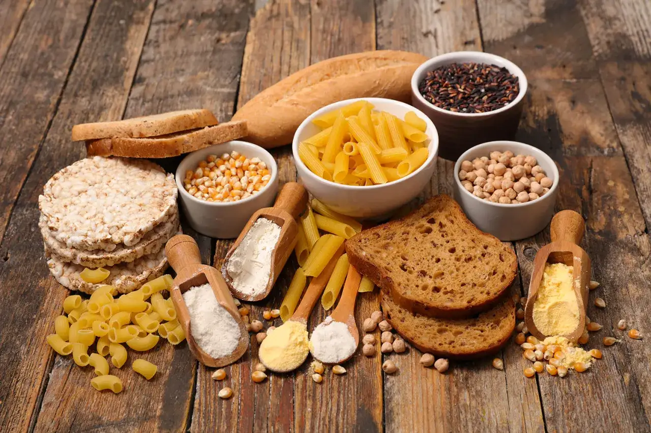 Chleb, makaron, ryż, ciecierzyca i mąki na drewnianym stole. To może być inspiracja na miesiąc bez glutenu efekty.