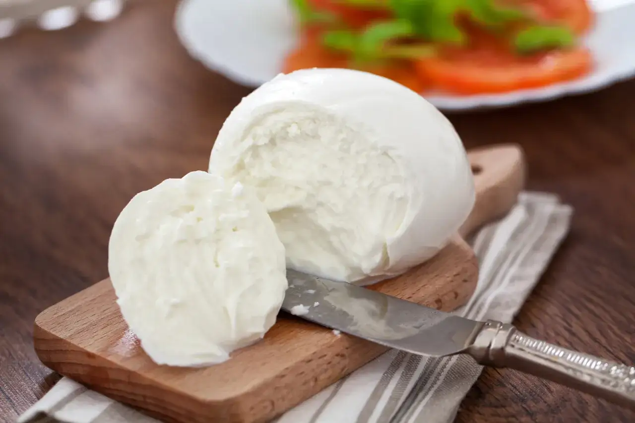 Świeża mozzarella na desce, gotowa do sałatki. Zastanawiasz się, ile białka ma mozzarella? To świetne źródło protein!