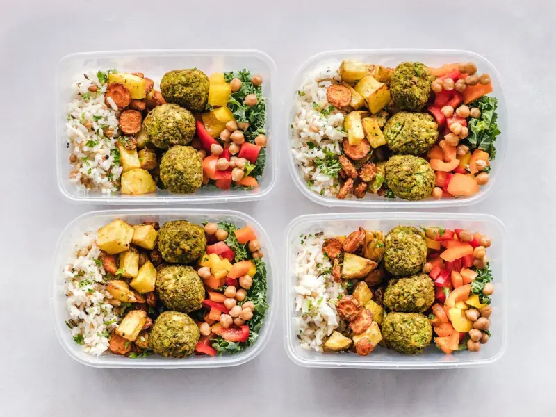 Cztery pojemniki z posiłkami: ryż, pieczone ziemniaki, marchewka, falafel, ciecierzyca i warzywa. Idealne na dieta 3000 kcal jadłospis tygodniowy.